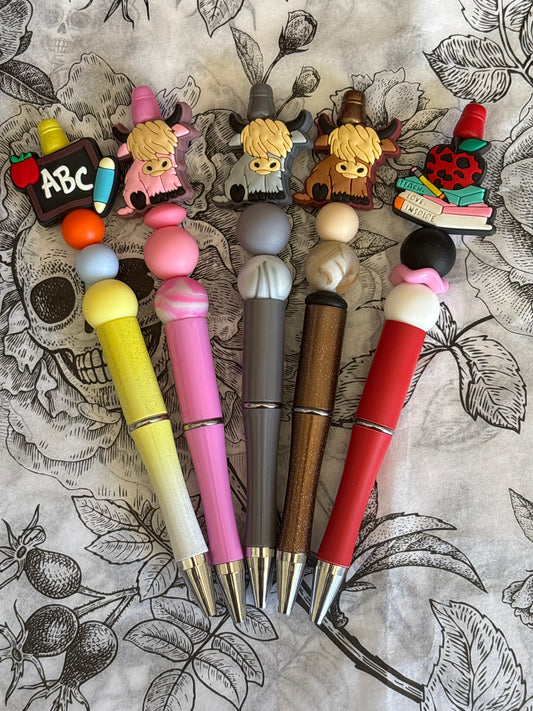 Set of colorful pens with decorative ends on a patterned background