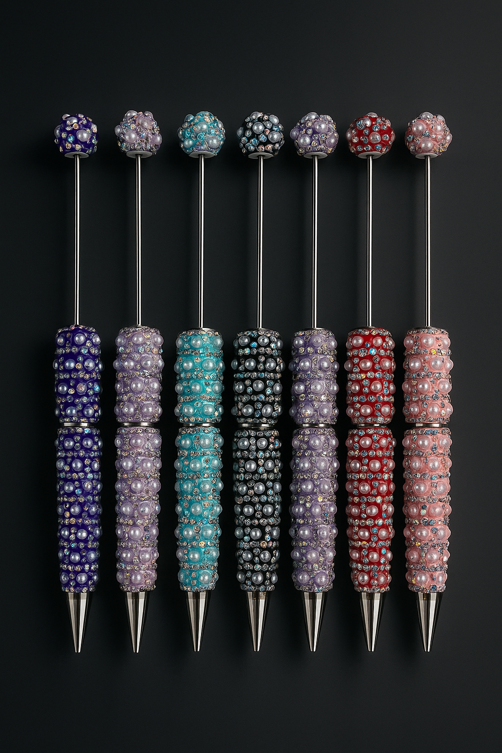 Set of decorative pens with colorful bead embellishments on a black background